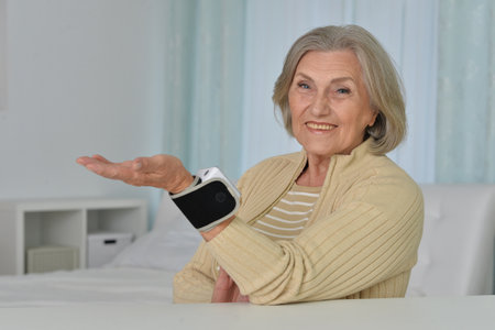 Smiling old woman using automatic carpal tonometer in hospitalの写真素材