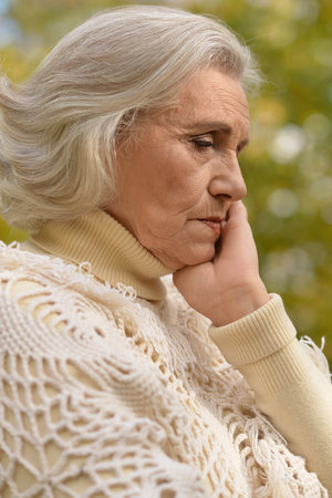 Nice sad old woman on the autumn backgroundの写真素材