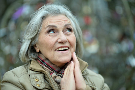 Senior woman walking in the park in autumn.