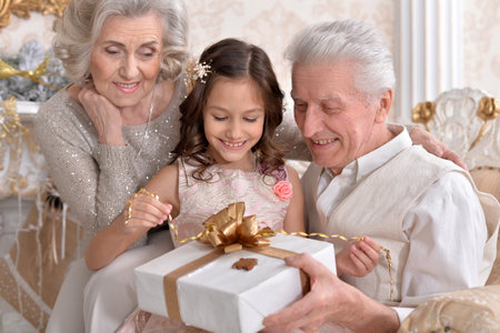 Grandparents with grandchild preparing for Christmas togetherの写真素材