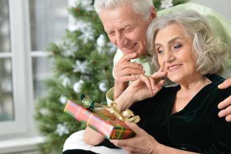 Happy elderly couple celebrating new year at homeの写真素材