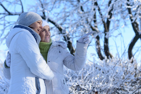 Happy women in winter clothes posing outdoors
