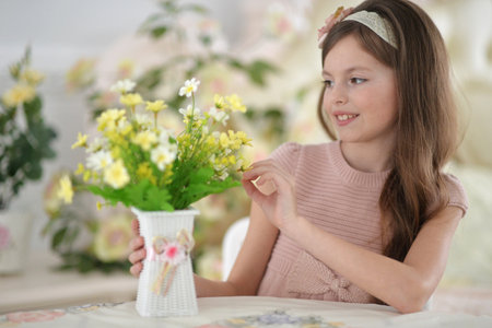 A smiling teenage girl poses with flowersの写真素材