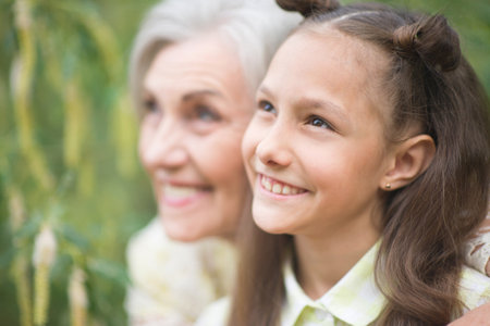 Portrait of happy grandmother and granddaughter in parkの写真素材