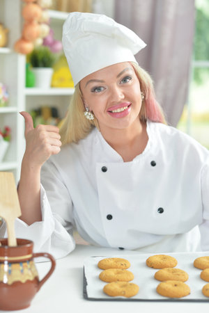 Beautiful young chief woman baking in kitchenの写真素材