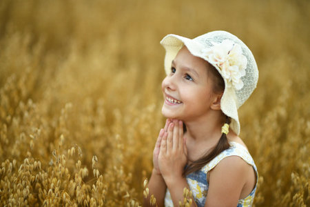Cute little girl in the wheat field.の写真素材
