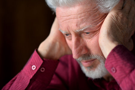 close-up portrait of a senior man thinking about something