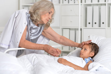 The little girl is in the hospital with her grandmotherの写真素材