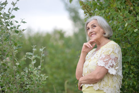 Portrait of a beautiful elderly woman in the parkの写真素材