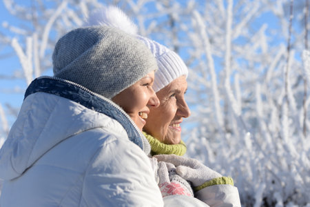 Beautiful elderly woman and her daughter enjoy winter together.の写真素材