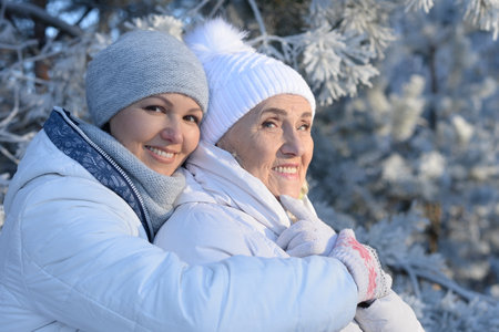 Beautiful elderly woman and her daughter enjoy winter together.の写真素材