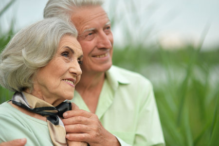 Beautiful elderly couple hugging in the parkの写真素材