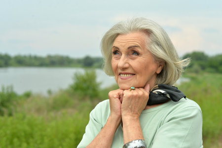Portrait of a beautiful elderly woman in the parkの写真素材