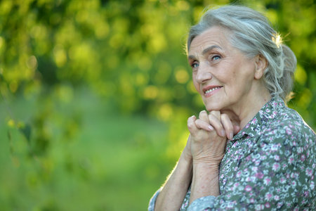 Portrait of a beautiful elderly woman in the parkの写真素材