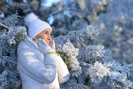 Beautiful elderly woman posing in a snowy winter parkの写真素材