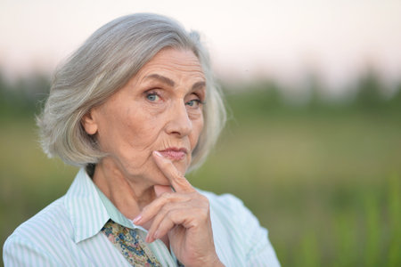 Portrait of a beautiful elderly woman in the parkの写真素材