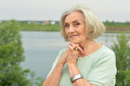 Portrait of a beautiful elderly woman in the parkの写真素材
