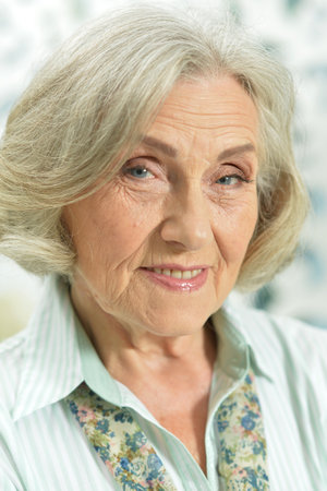 Portrait of smiling senior woman posing at homeの写真素材