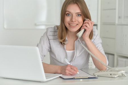 Female office worker reacting to phone call.の写真素材