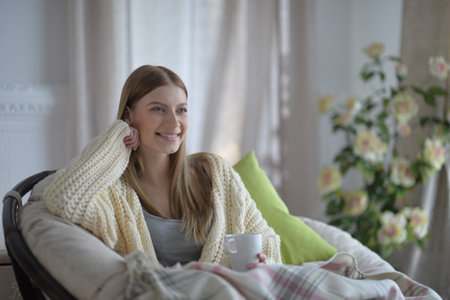 Portrait of young woman in pajamas with fluffy plaidの写真素材