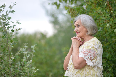 Portrait of a beautiful elderly woman in the parkの写真素材