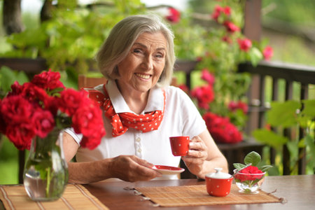 Portrait of happy aged woman drinking coffeeの写真素材
