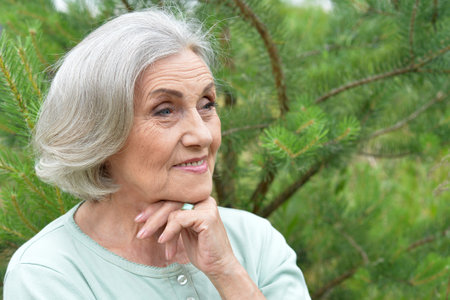 Portrait of a beautiful elderly woman in the parkの写真素材