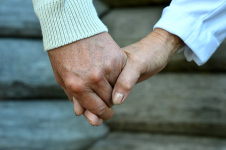 Close-Up of Elderly Hands Holding in Supportの写真素材