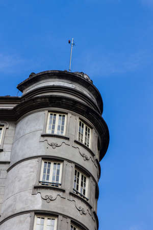Low angle detail view of an old rounded concrete business building in downtown with clear blue sky in the background.の写真素材