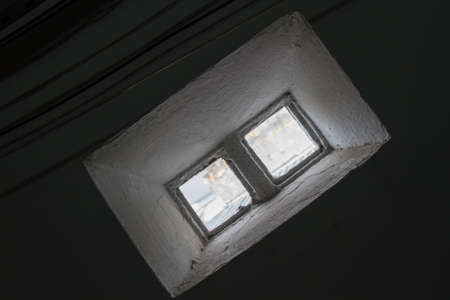 A tiny window made of 2 glass bricks illuminates the ambient and electric black wires passing by. No people. Brazil. South America.の写真素材