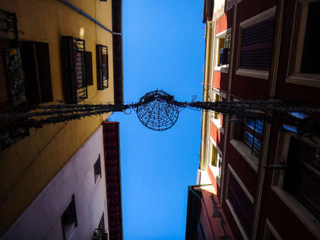City light between residential low buildings on a street in Europeの写真素材