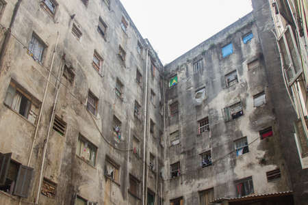 An abandoned building now occupied by social housing movement with white sky on the background. Internal view of the complex in C shape of this timeworn construction. San Paolo, Brazil, South America.の写真素材