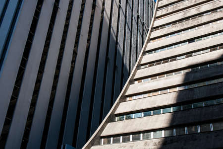Rounded corporate concrete building detail view with shadows on the wallsの写真素材