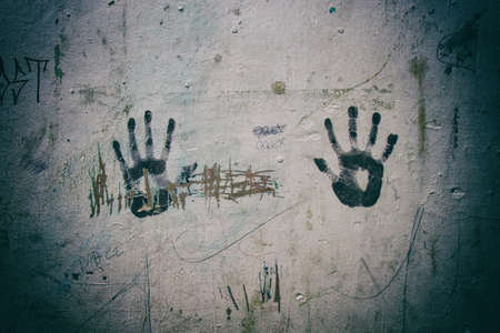 Right and Left black hand print marks on a ruined dirty white wall. Wallpaper.の写真素材