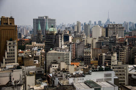 Skyline of the metropolis with concrete old and aged buildings and a cathedral with green roof.の写真素材