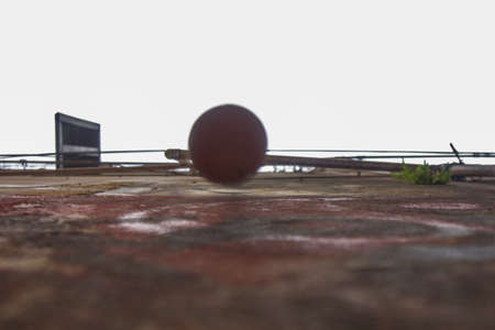 Low angle view of a plastic pipe on an eroded red and black wall and a window with blinds open.の写真素材