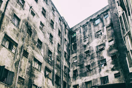 An abandoned building now occupied by social housing movement with white sky on the background. Internal view of the complex in C shape of this timeworn construction. San Paolo, Brazil, South America.の写真素材