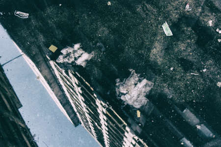 Condemned abandoned building is home for hundreds of social housing movement people reflection on a puddle with blue sky on the background.の写真素材