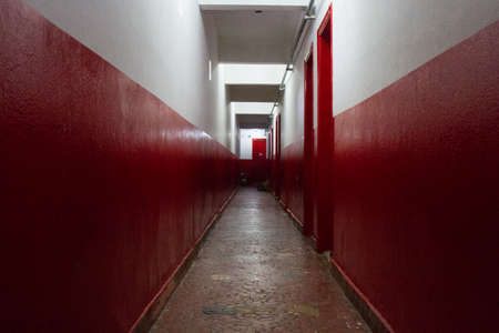In abandoned building now occupied by social housing movement some floors were painted. In this corridor, each wood door is home for a family of the social movement. San Paolo, Brazil, South America.の写真素材