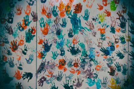 Wall painted by colourful children handprint in green, red, yellow, orange, blue and purple.の写真素材