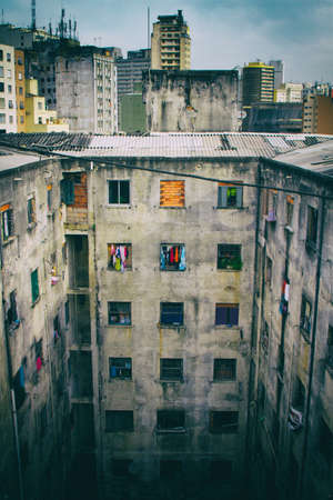 A ruined abandoned c shape building with square windows in San Paolo, Brazil, used as slum by a social housing movement. No people.の写真素材