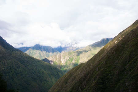 Sun illuminating the valley while the clouds hide the mountain on the background. No people.の写真素材