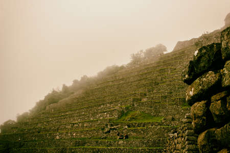 Beautiful wallpaper photo of Inca agriculture stone terraces with fog. Inca Trail. Peru. No people.の写真素材
