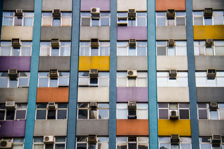 Detail of business building windows with walls paintes in yellow, grey, orange, white and purple.