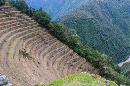 Agriculture centre terraces covered by grass with the Andes mountains on the background on the Inca Trail to Machu Picchu, Peru. Beautiful wallpaper.の写真素材