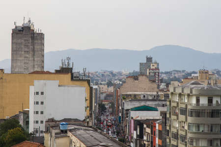 Mountains on the background of old residential, business and commercial buildings of the city skyline. San Paolo, Brazil. No people.の写真素材