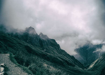A mountain in the background almost hidden by the clouds and fog in the wild Andes along the Inca Trail. Peru. South America. No people.の写真素材
