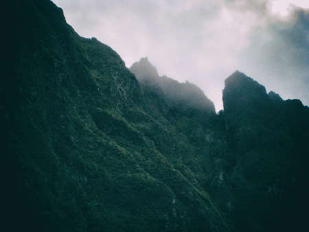 A mountain in the background almost hidden by the clouds and fog in the wild Andes along the Inca...