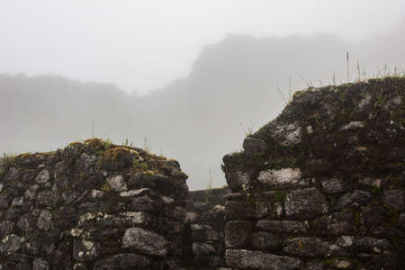 Historical ruins of the ancient Inca civilization covered by fog at dawn along the paved path Inca Trail in the Andes mountains in Peru, South America. Inspiring mysterious images.の写真素材