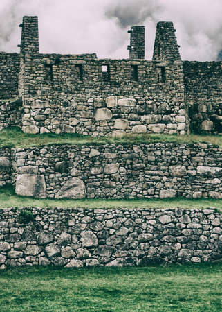 Vertical view of Machu Picchu stone ruins lost in the wild nature of the Andes mountains. Peru....